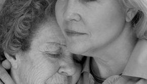 A daughter comforts her elderly mother