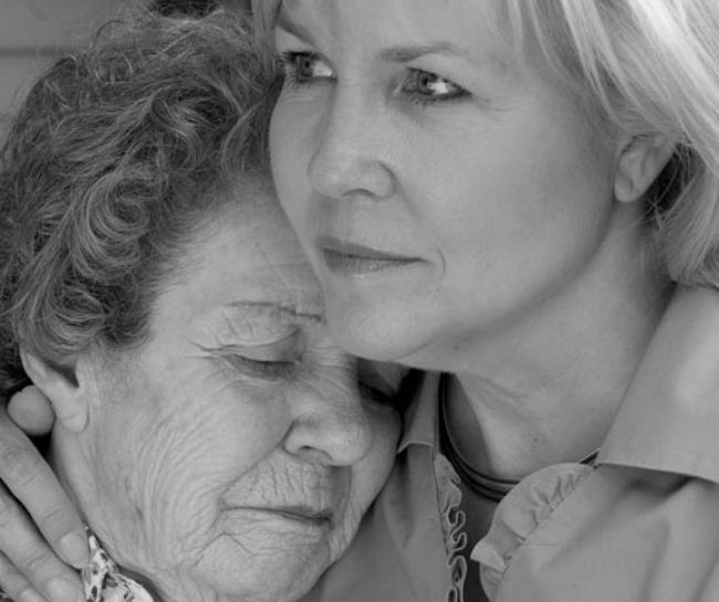 A daughter comforts her elderly mother