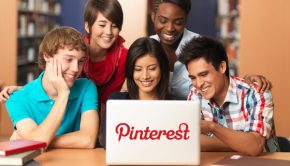 Several young adults surround a computer using Pinterest