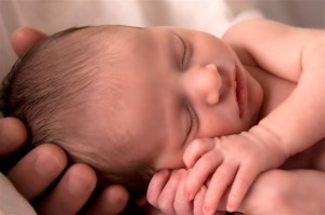 Parent holds an infant in their hands