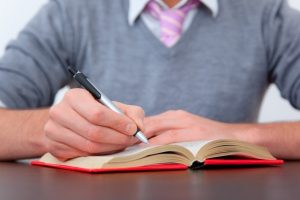 Man writes in a journal