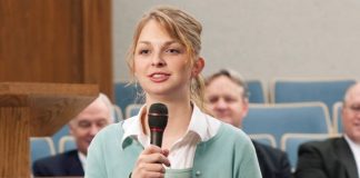 girl holds a microphone speaking at church on sunday