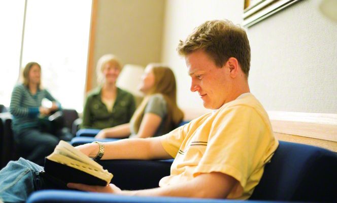 A young man studying his scriptures