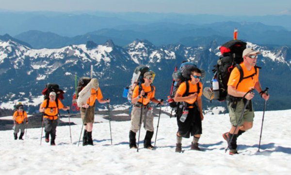 Boys climbing a mountain on snowshoes