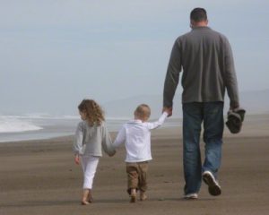 Dad and kids walking on the beach