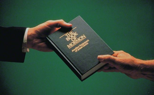 man giving book of mormon