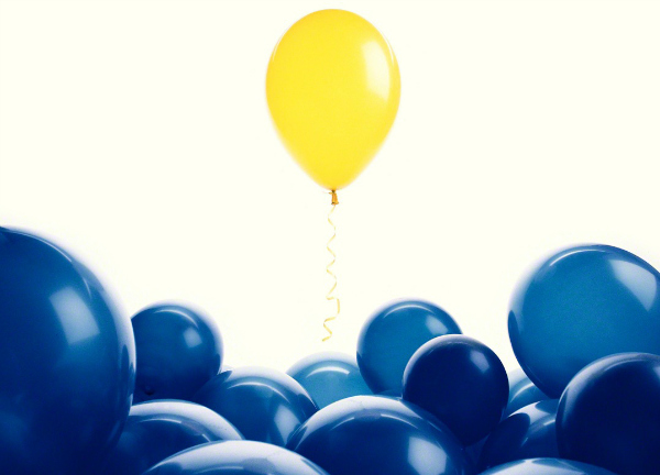 Yellow balloon among blue balloons