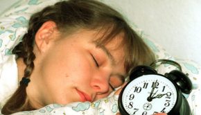 sleeping girl with alarm clock next to her