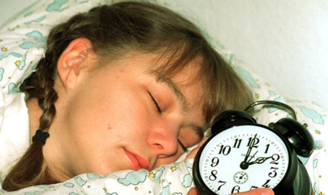sleeping girl with alarm clock next to her
