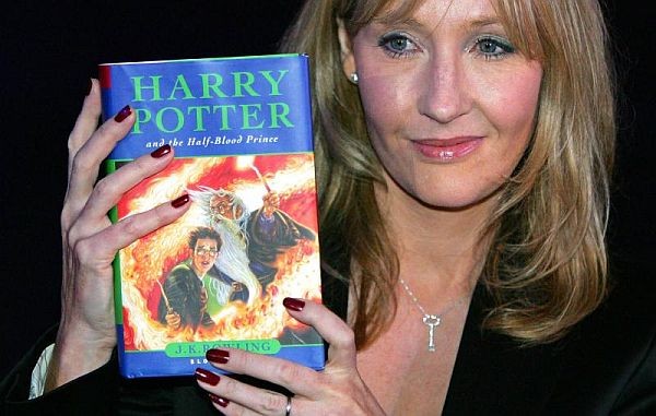 JK Rowling holds up a Harry Potter book