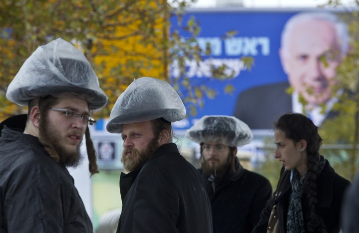 ultra-orthodox Jews covering their hats in the rain