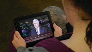 Woman watches conference on her tablet