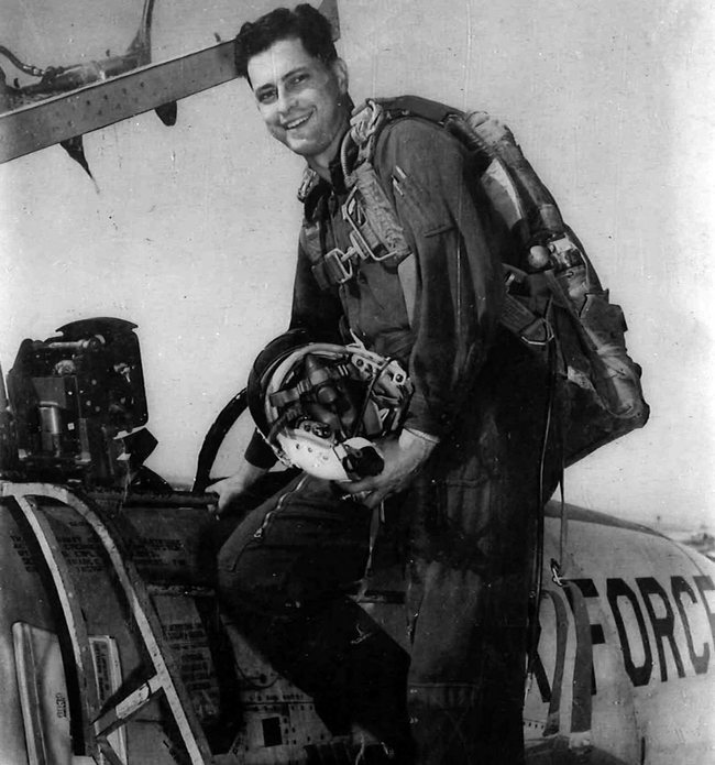 Robert D. Hales climbing into a plane cockpit