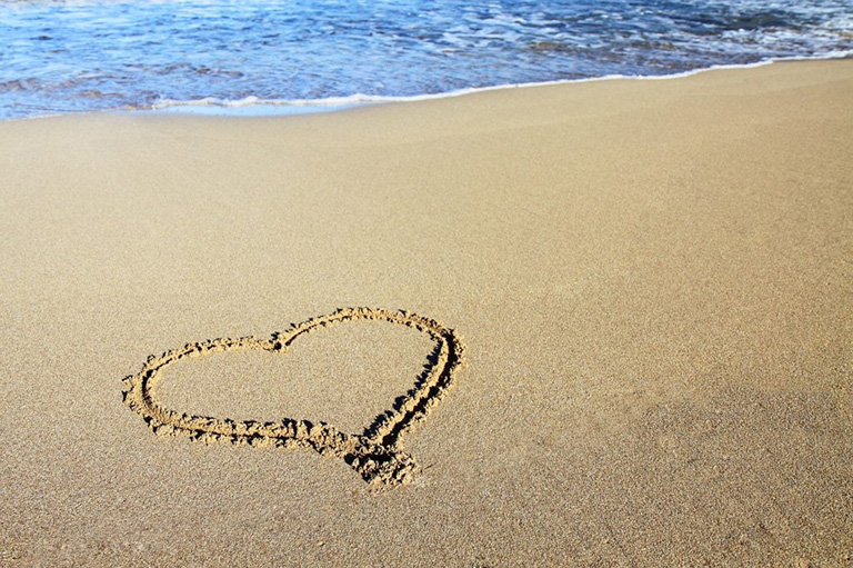 Heart design drawn into the sand on the beach