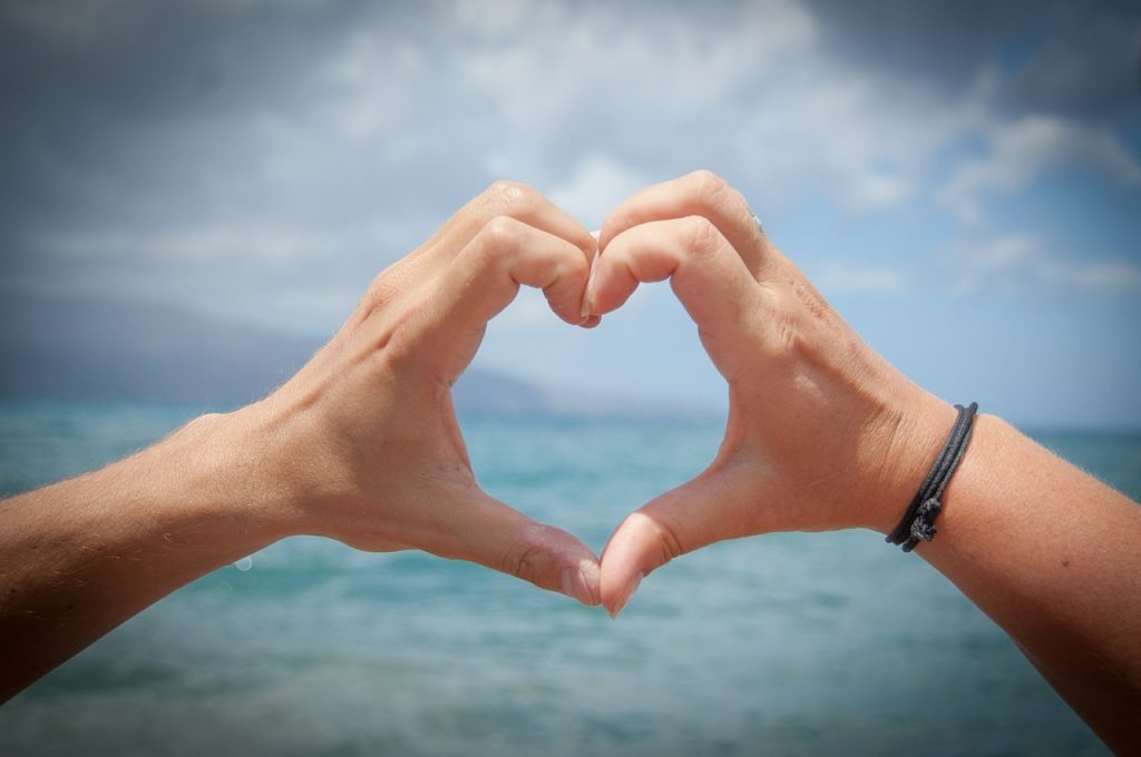 Picture of a couple making the shape of a heart with their hands