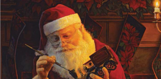 Santa Claus painting a toy train