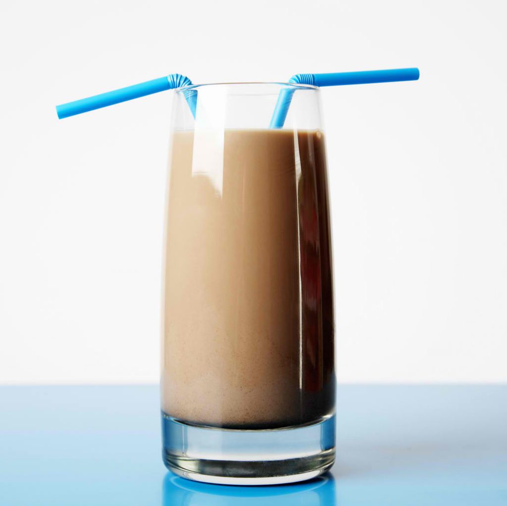 chocolate milk in a glass with two straws