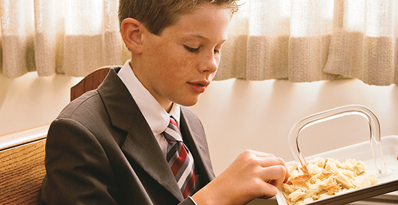 Young man partaking of the sacrament bread