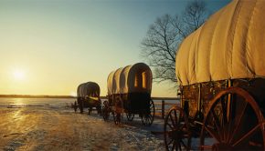 Pioneer wagons travel down snowy trail