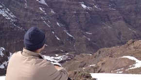 Man sitting in mountains contemplating