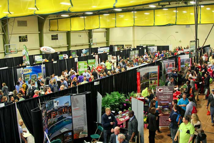 Lots of people looking at booths in a gym at the national landscape competition