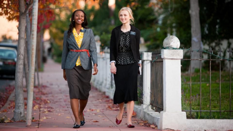 Two LDS women missionaries walking down the sidewalk