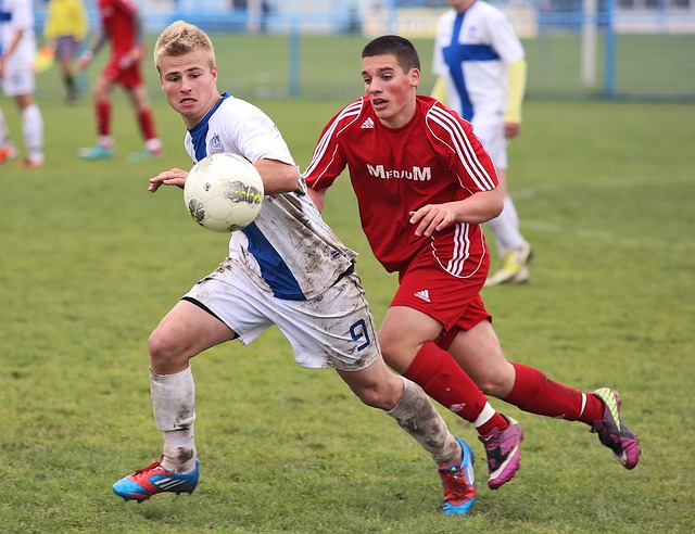 Two intramural soccer players running after a soccer ball