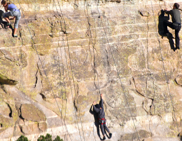 people climbing up a rock wall