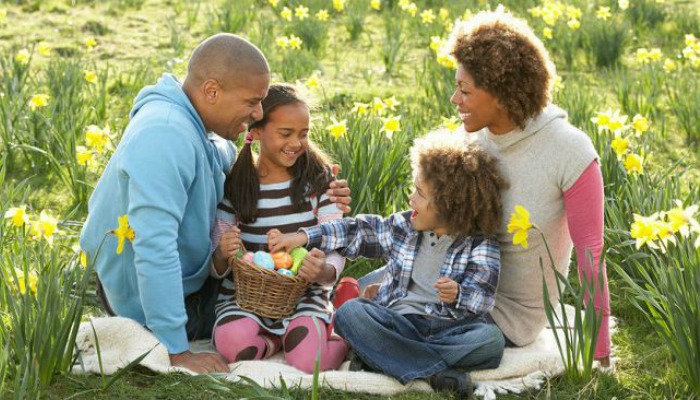 “A couple and their two children enjoying an outside picnic.