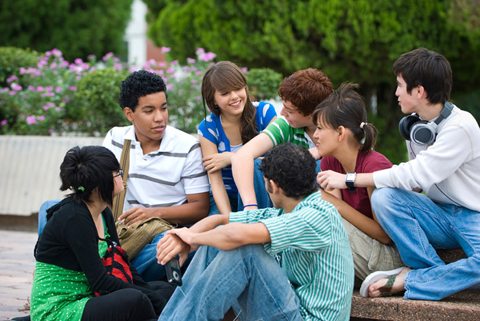 Group of teenagers sitting down talking with each other