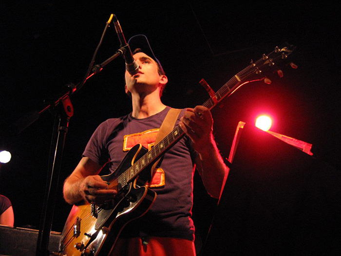 Man playing a guitar and singing on stage