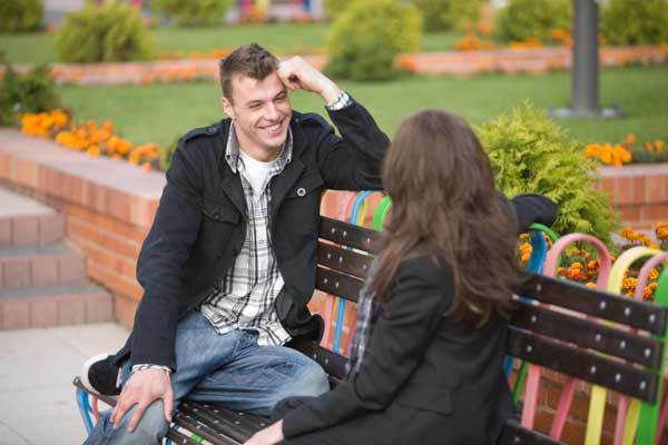 A man meeting a woman on a park bench