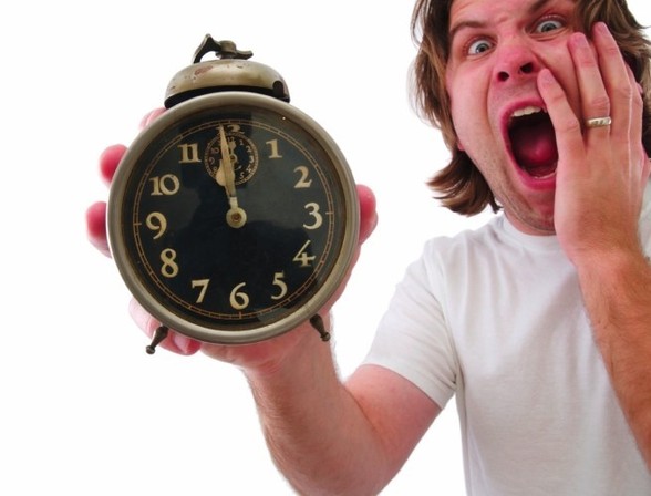 man holding a clock freaking out because he is running out of time. Image via todayfm.com