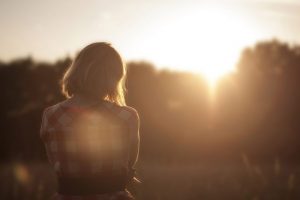 A woman watches a sunset all alone