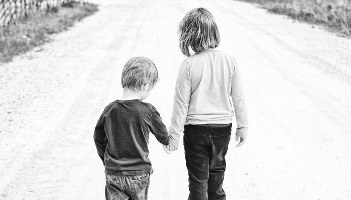 Sister leading little brother by the hand