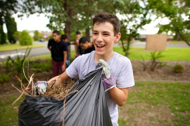 A Young Boy Doing Yard Work and Smiling