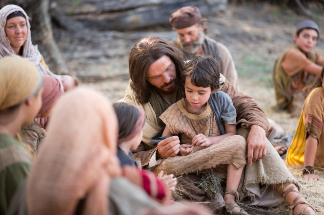 Jesus sitting on the ground with a child