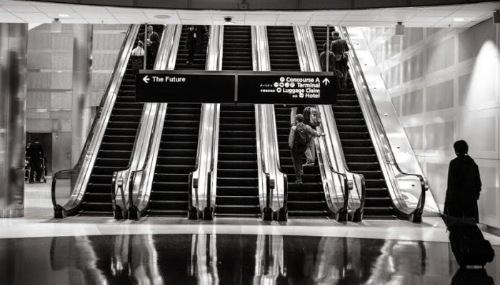 a set of escalators in an airport photographed in black and white
