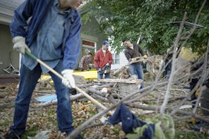 Men cleaning up fallen trees during service project