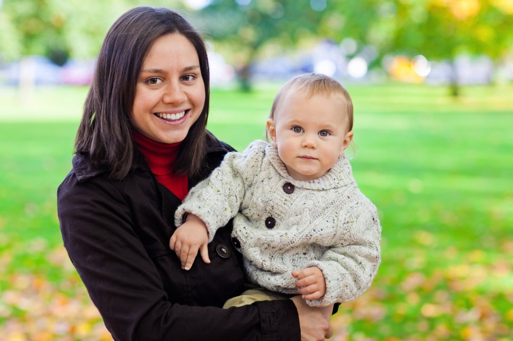 Babysitter taking a baby on a park outing