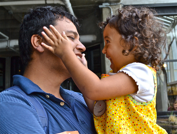 Father laughs with baby daughter