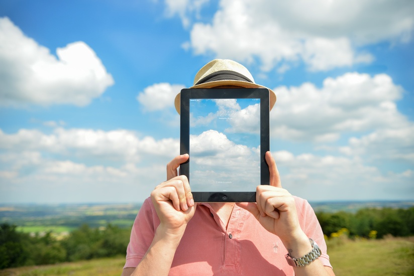 Man's face disappears behind his iPad