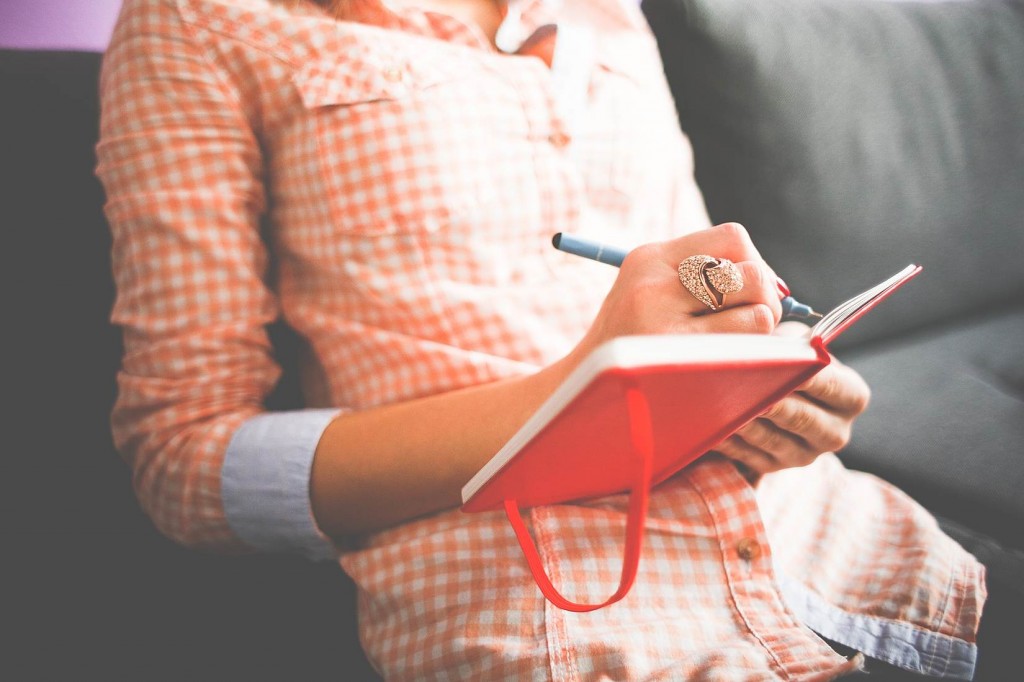 Woman writing testimony in a notebook