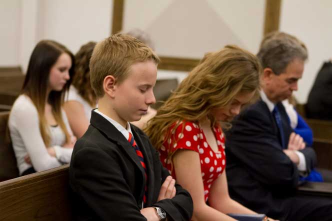 A family worshiping during sacrament meeting