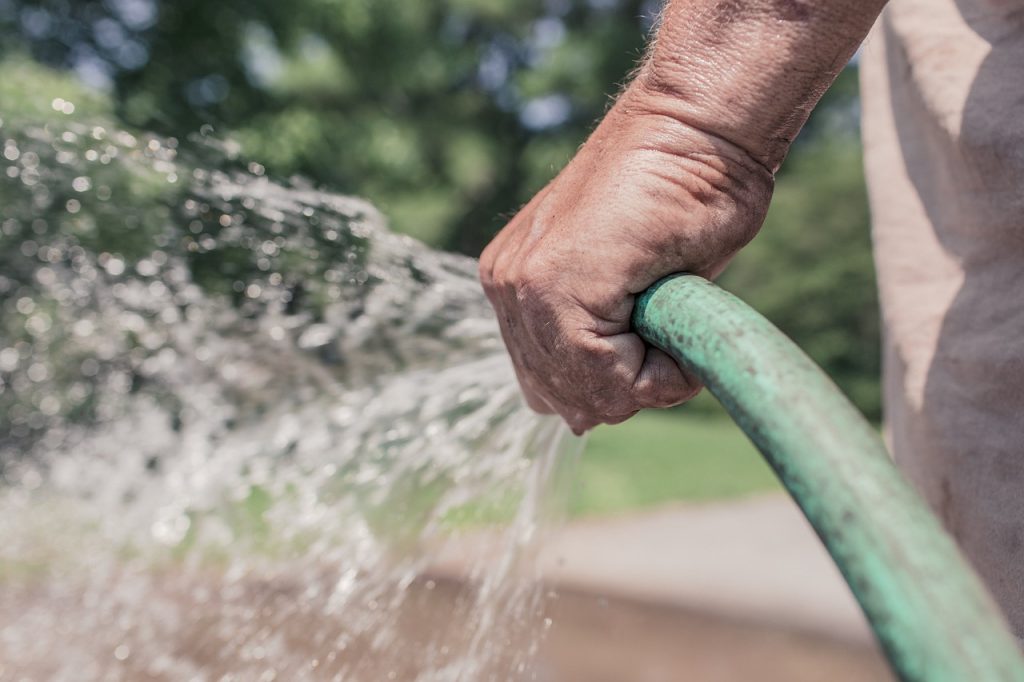 Hand holding a garden hose.