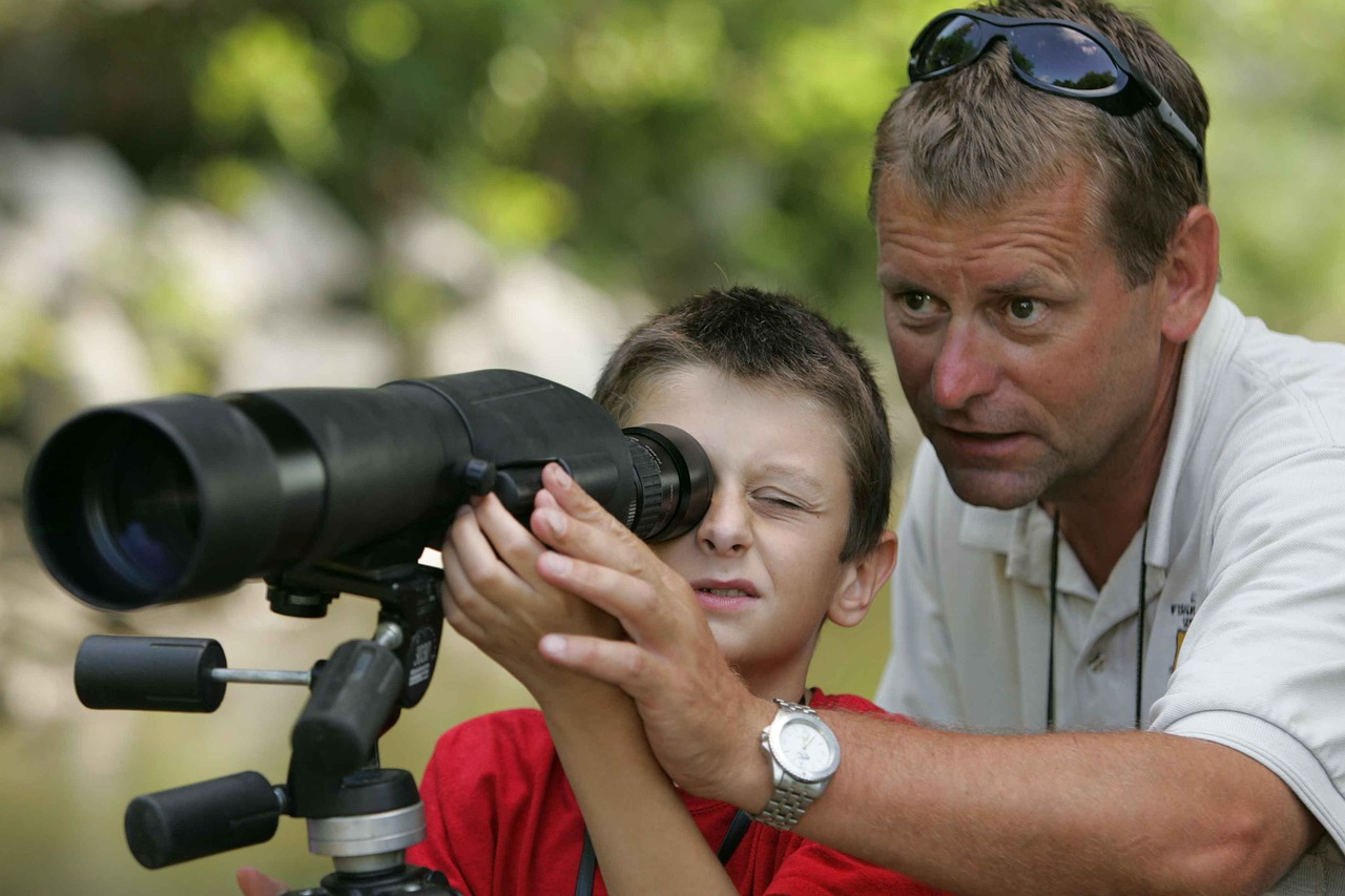 Father and son looking through telescope.