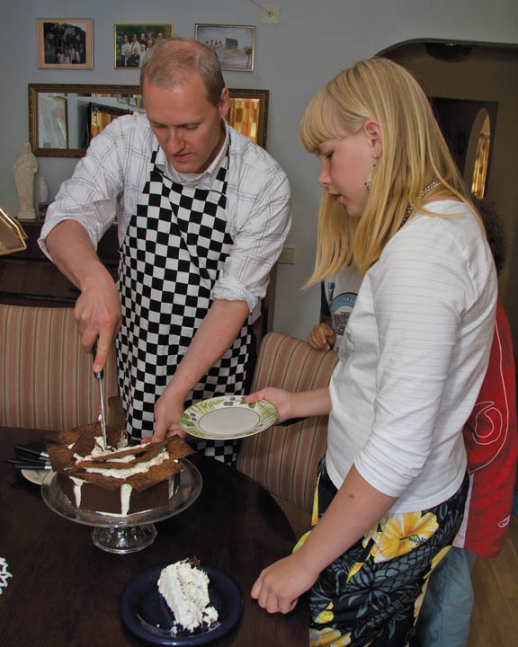 man and young woman cutting cake