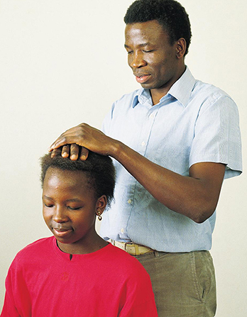 Father giving child a blessing at the start of a new school year. 