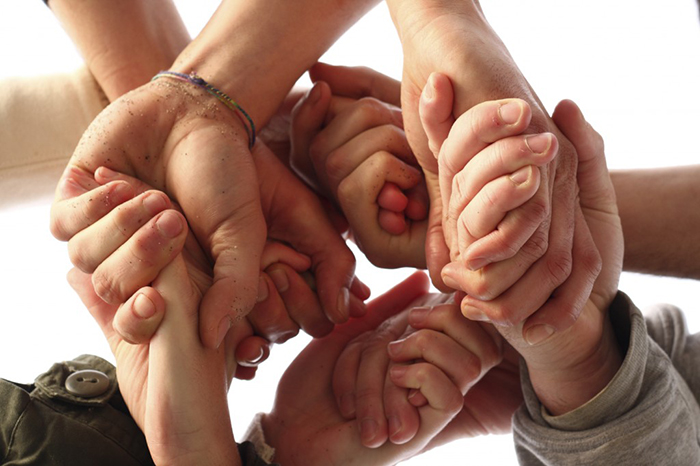 Various hands give each other support