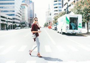 Christine Andrew wearing sunglasses and walking across a city street